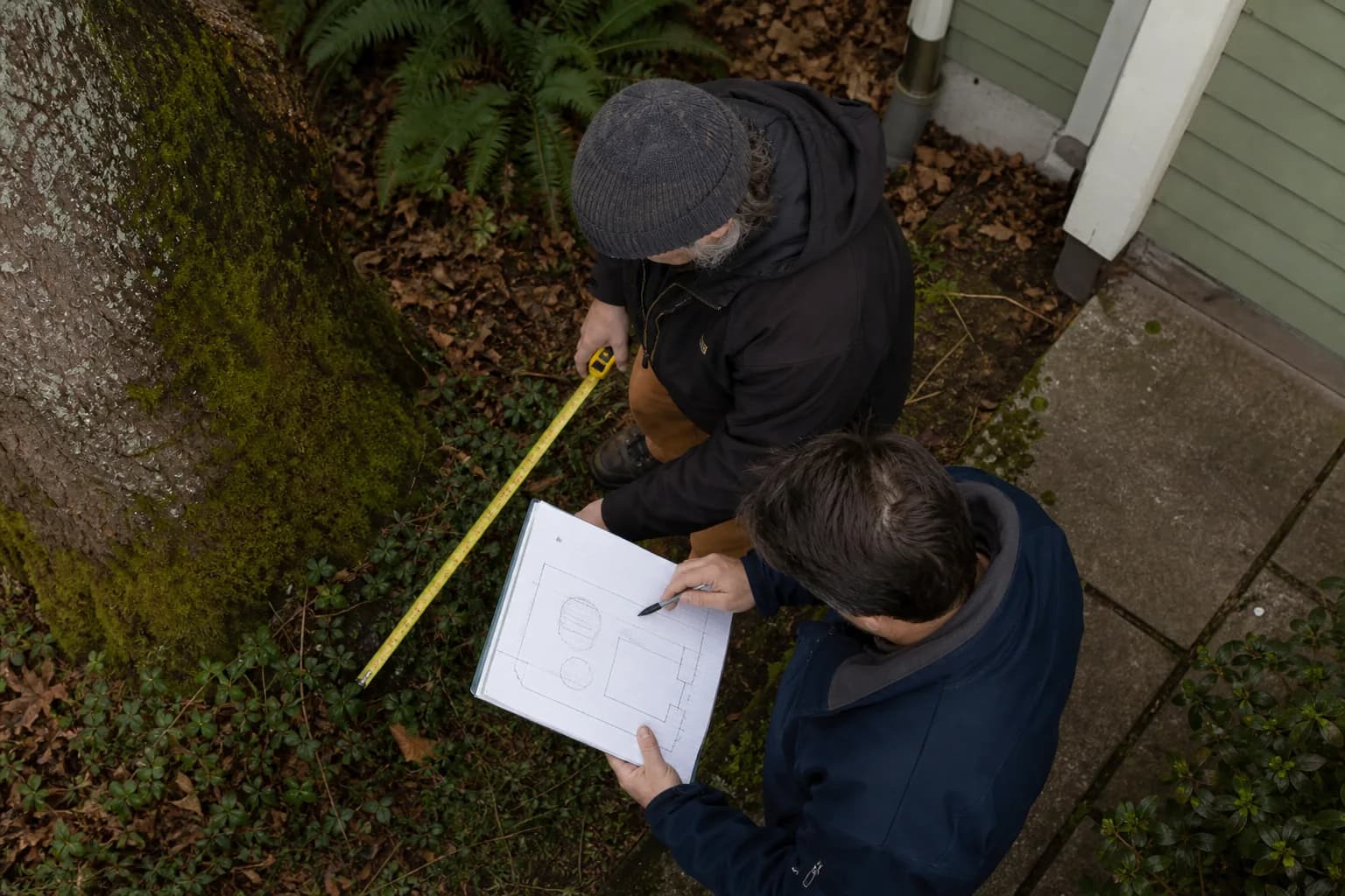 Contractor measuring tree and foundation access for a Eugene oil tank decommissioning